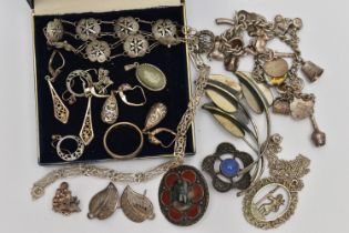 AN ASSORTMENT OF WHITE METAL JEWELLERY, to include two Scottish brooches, a charm bracelet fitted
