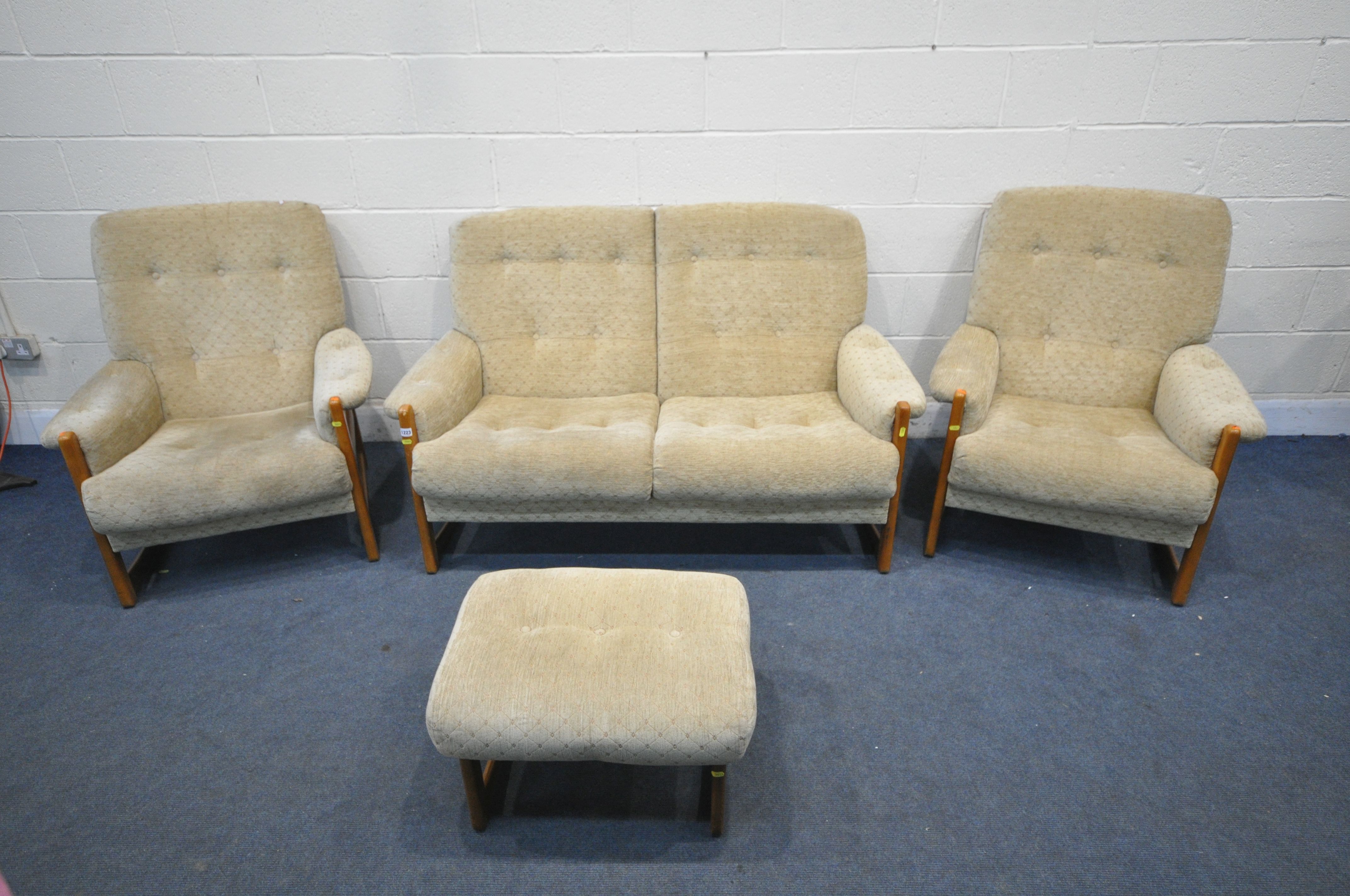 A MID CENTURY TEAK THREE PIECE LOUNGE SUITE, comprising a three seater settee, a pair of armchairs