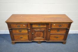 AN EARLY 20TH CENTURY OAK SIDEBOARD, with seven drawers, and central cupboard door, width 163cm x