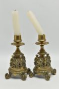 A PAIR OF VICTORIAN BRASS CANDLESTICKS, flowerhead shaped drip pans, short turned pedestals and