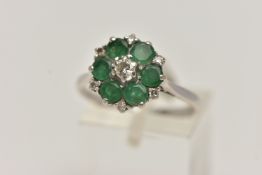 A WHITE METAL EMERALD AND DIAMOND CLUSTER RING, circular cluster, set with a central raised round