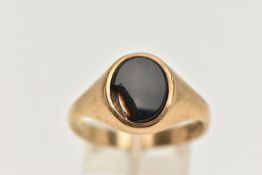 A 9CT GOLD SIGNET RING, of an oval form, set with a polished onyx inlay (AF chipped), to a