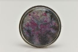A WHITE METAL ‘RUSKIN’ BROOCH, of a circular form, painted ceramic insert, signed to the reverse ‘