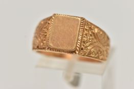 A YELLOW METAL SIGNET RING, polished rectangular signet to scrolling floral shoulders and polished