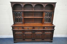 AN OLD CHARM OAK DRESSER, the top with a three tier plate rack, flanked by two lead glazed doors,