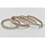 FOUR SILVER HINGED BANGLES, to include two hollow hinged bangles, engraved with foliage detail, a