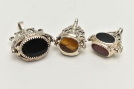 THREE WHITE METAL SWIVEL FOB PENDANTS, each set with semi-precious gemstones such as bloodstone,