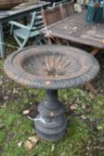 A CAST IRON URN OF A SHALLOW FORM, the circular campagna top on a turned and foliage design base,