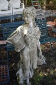A WEATHERED COMPOSITE GARDEN STATUE, of a scantily lady carrying baskets, height 136cm (condition