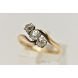 A YELLOW METAL THREE STONE DIAMOND RING, cross over design, set with three old cut diamonds,