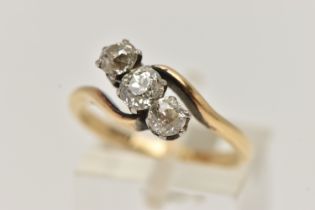 A YELLOW METAL THREE STONE DIAMOND RING, cross over design, set with three old cut diamonds,