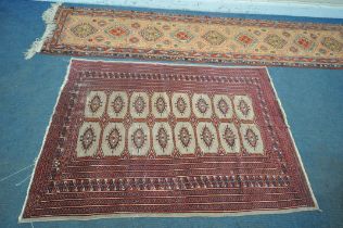 A RED GROUND WOOLEN TEKKE RUG, with sixteen medallions and a multi strap border, 182cm x 128cm,