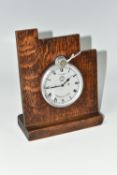 A JAEGER FOUR DAY CAR CLOCK, fitted into an oak mount, the silver coloured dial having Roman numeral