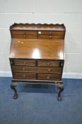AN EARLY TO MID 20TH CENTURY MAHOGANY BUREAU ON STAND, with a wavy gallery back, with nine