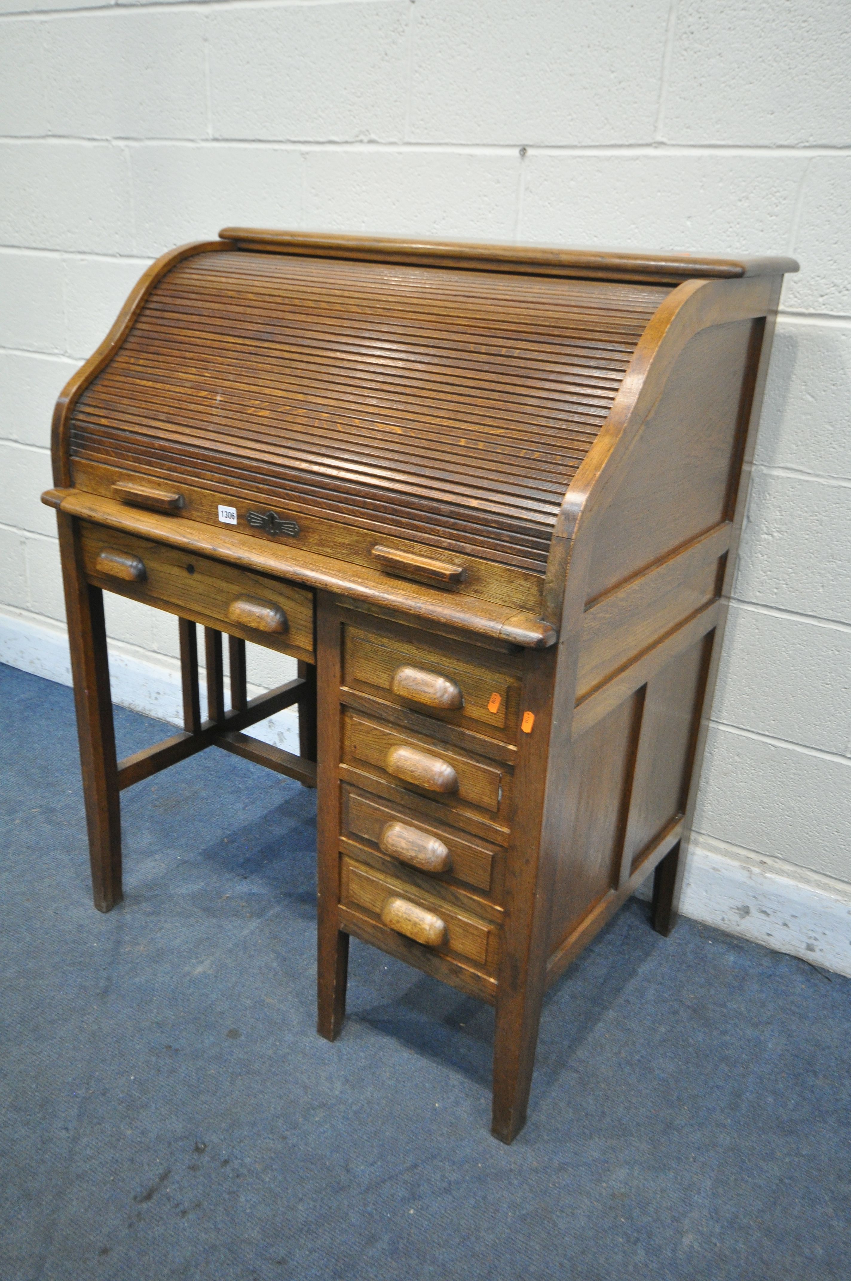 AN EARLY TO MID 20TH CENTURY OAK ROLL TOP DESK, enclosing an arrangement of pigeon holes, over