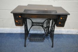 AN OAK CASED SINGER TREADLE SEWING MACHINE, on a cast iron base, serial number Y1457188, length 91cm