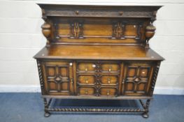 A 20TH CENTURY JACOBEAN STYLE OAK DRESSER, the raised back with blind fretwork