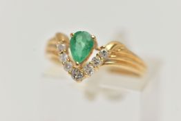 AN EMERALD AND DIAMOND RING, the pear shape emerald with a v-shape line of brilliant cut diamonds