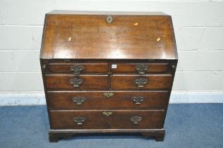 A GEORGIAN OAK BUREAU, the fall front door enclosing a fitted interior, above two dummy drawers, two