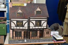 A WOODEN DOLLS HOUSE, modelled as an Elizabethan style half-timbered house, front opening to