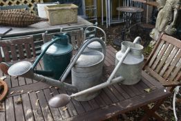 THREE VINTAGE GALVANISED WATERING CANS, one labelled HAWS of Stourbridge, another stamped BAT, and a