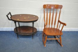 A MODERN STAINED BEECH ROCKING CHAIR, and an oval mahogany two tier tea trolley, with raised wavy