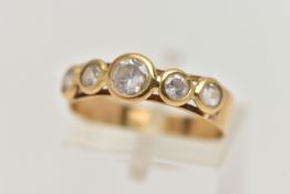 A YELLOW METAL FIVE STONE RING, set with five circular cut paste, to a polished band, stamped 750,