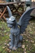 A HEAVY CAST IRON GARDEN SCULPTURE, of a mythical dragon with outspread wings, width 62cm x depth
