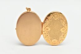 A YELLOW METAL OVAL LOCKET, floral pattern to the front, opens to reveal two vacant photo