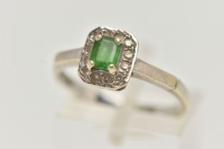 A 9CT WHITE GOLD GEM SET RING, set with a central emerald, in a surround of round brilliant cut