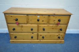 A MODERN PINE SIDEBOARD, with three short drawers over four long drawers, length 133cm x depth
