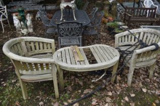 A PAIR OF WEATHERED TEAK BANANA ARMCHAIRS, and a matching table (condition report: weathered, no