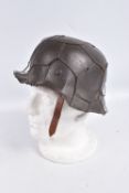 A BATTLE DAMAGED WWII ERA GERMAN STEEL HELMET WITH CAMOUFLAGE WIRE NETTING, this helmet still has