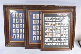 THREE FRAMED AND GLAZED DISPLAYS OF CIGARETTE CARDS FEATURING BRITISH ARMY UNIFORMS AND HEADDRESS,