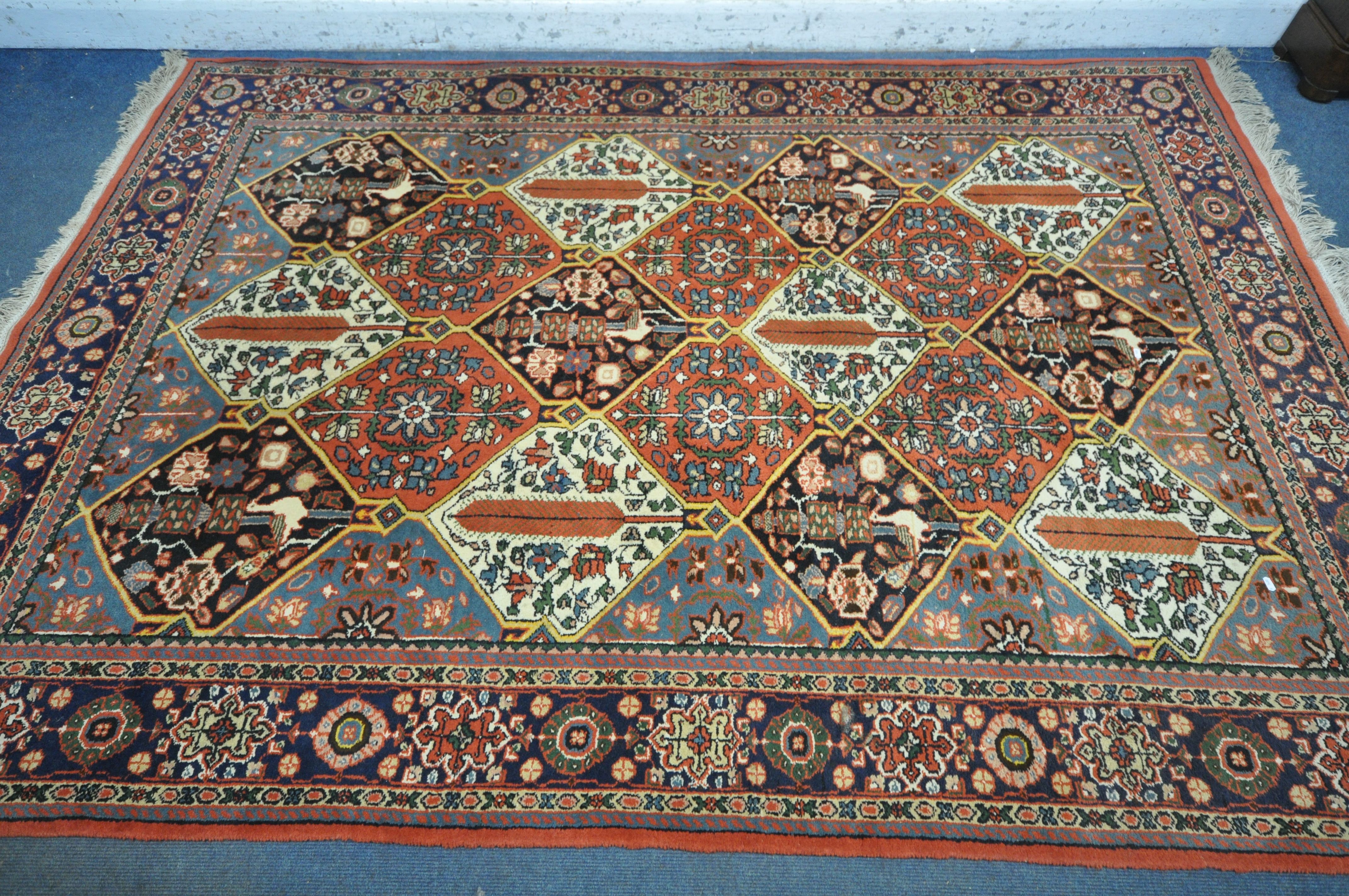 A WOOLMARK RED GROUND RUG, with geometric and floral design, 287cm x 283cm (condition report: