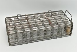 AN INDUSTRIAL GALVANISED METAL STORAGE RACK, containing thirty-six glass bottles with metal lids,