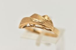 A YELLOW METAL ABSTRACT RING, textured fan detail, to a polished band, unclear marks to the