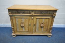 A 19TH CENTURY PINE DRESSER BASE, with two drawers, over two cupboard doors, with foliate carved
