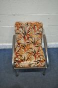 A MID CENTURY TUBULAR METAL ARMCHAIR, with leatherette back rest and seat, with floral upholstered