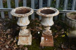 A PAIR OF CAST IRON CAMPAGNA URNS, of smaller proportions, on a separate plinth, diameter 29cm x