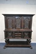 AN EARLY 2OTH CENTURY CARVED OAK CABINET ON STAND, fitted with an arrangement of five cupboard doors
