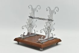 A CHROME DESK TOP PEN STAND, pierced tree design on both sides, supported by four ball feet,