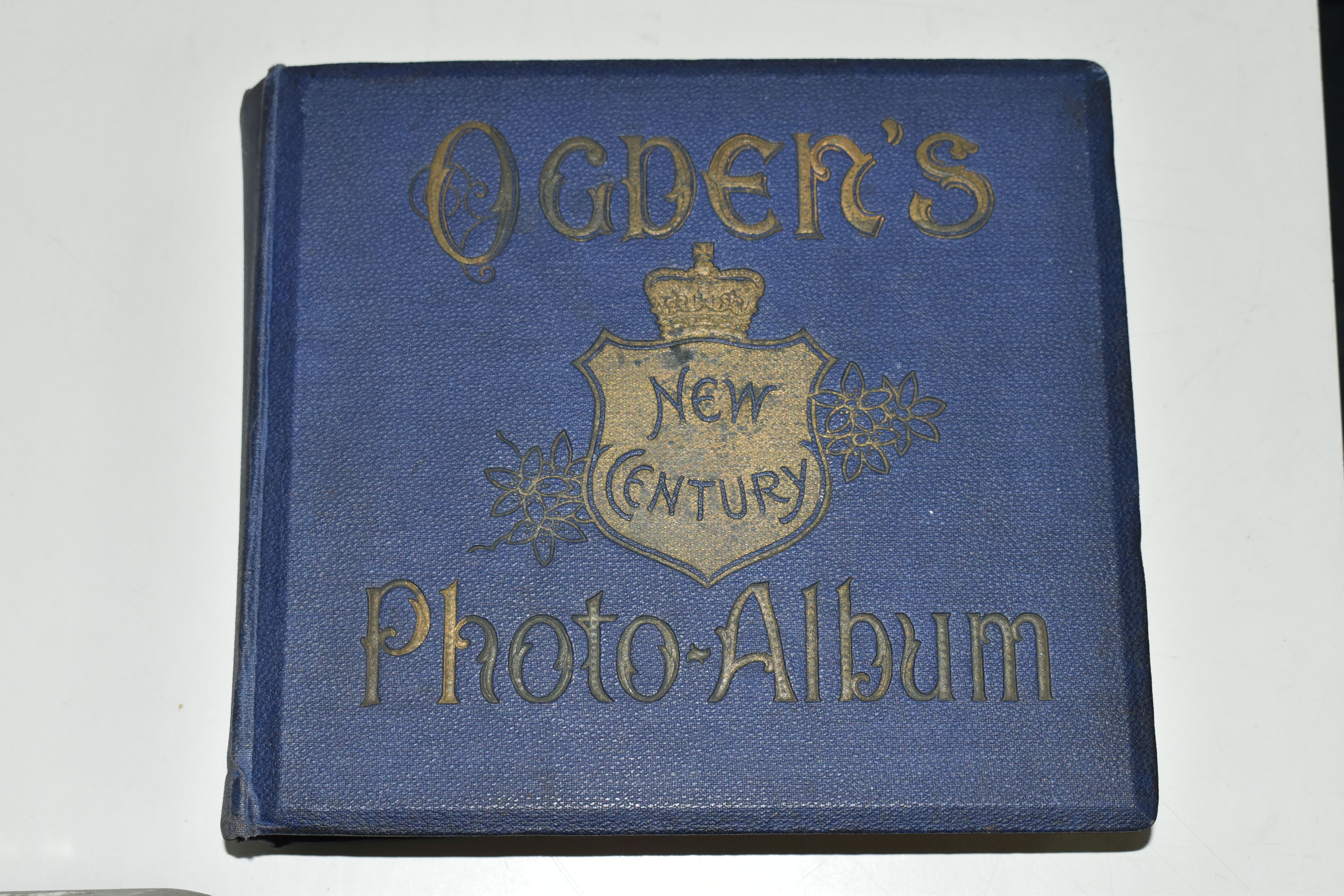AN OGDEN'S NEW CENTURY PHOTOGRAPH ALBUM containing 199 Ogden's Guinea Gold Cigarette Cards featuring