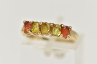 A 9CT GOLD GEM SET RING, designed as a line of oval cut gems, the central three assessed as possibly