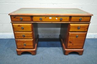 A DUCAL PINE KNEE HOLE DESK, with green leather writing surface and an arrangement of eight