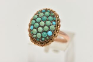 A TURQUOISE RING, the oval panel set with circular turquoise cabochons, some replacements, to the