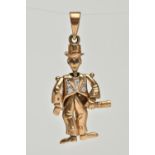 A 9CT GOLD ARTICULATED MAN PENDANT, gentlemen holding a bottle with top hat on, set with blue