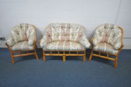 A WICKER THREE PIECE CONSERVATORY SUITE, comprising a two seater sofa and two armchairs (condition