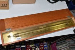 A CASED BRASS ENGINEERS ROLLING RULE, no makers marks, width approx. 61.5cm, rule and case with some