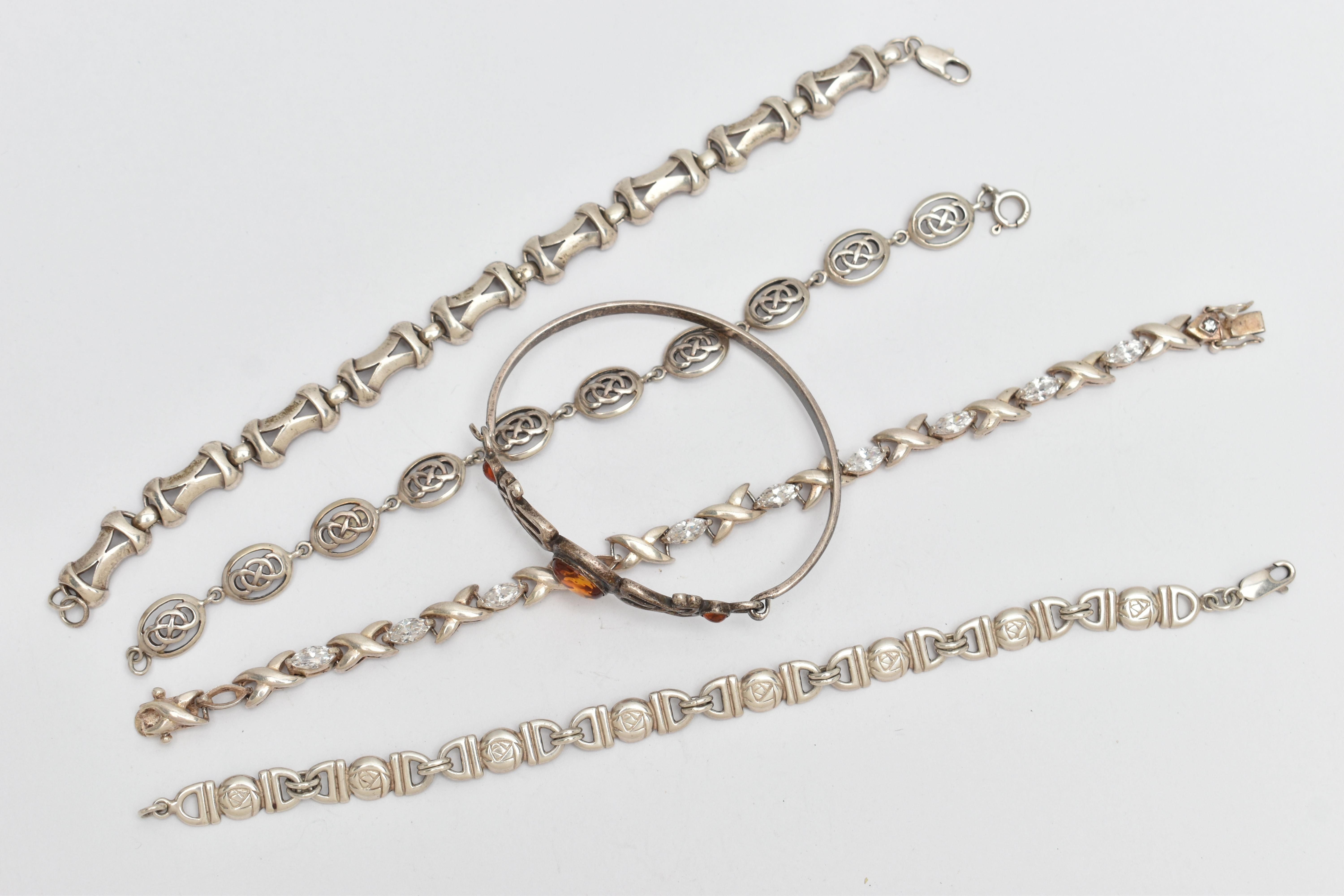 FIVE BRACELETS, to include a white metal hinged bangle set with amber cabochons, stamped 925, a